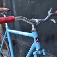 This fixed gear bicycle is called "The Maquis" and features red rims and a sky blue frame.