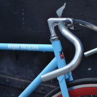 This fixed gear bicycle is called "The Maquis" and features red rims and a sky blue frame.