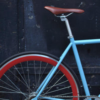 This fixed gear bicycle is called "The Maquis" and features red rims and a sky blue frame.