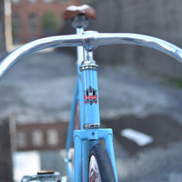 This fixed gear bicycle is called "The Maquis" and features red rims and a sky blue frame.