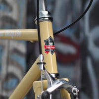 This fixed gear bicycle is called "The Count" and features white rims and a cream frame.