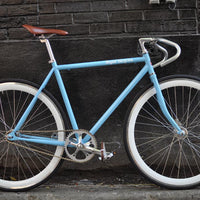 This fixed gear bicycle is called "The Prince" and features white rims and a sky blue frame.
