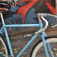 This fixed gear bicycle is called "The Prince" and features white rims and a sky blue frame.