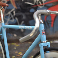 This fixed gear bicycle is called "The Prince" and features white rims and a sky blue frame.