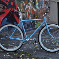 This fixed gear bicycle is called "The Prince" and features white rims and a sky blue frame.