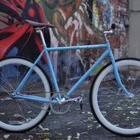 This fixed gear bicycle is called "The Prince" and features white rims and a sky blue frame.