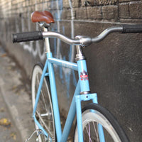 This fixed gear bicycle is called "The Prince" and features white rims and a sky blue frame.