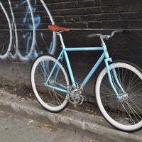 This fixed gear bicycle is called "The Prince" and features white rims and a sky blue frame.