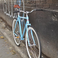 This fixed gear bicycle is called "The Prince" and features white rims and a sky blue frame.