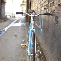 This fixed gear bicycle is called "The Prince" and features white rims and a sky blue frame.