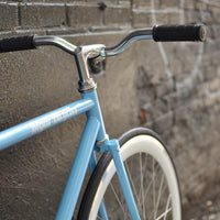 This fixed gear bicycle is called "The Prince" and features white rims and a sky blue frame.