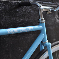This fixed gear bicycle is called "The Prince" and features white rims and a sky blue frame.