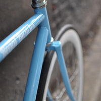 This fixed gear bicycle is called "The Prince" and features white rims and a sky blue frame.
