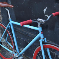 This fixed gear bicycle is called "The Maquis" and features red rims and a sky blue frame.