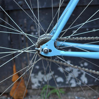 This fixed gear bicycle is called "The Maquis" and features red rims and a sky blue frame.