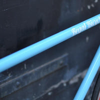 This fixed gear bicycle is called "The Maquis" and features red rims and a sky blue frame.