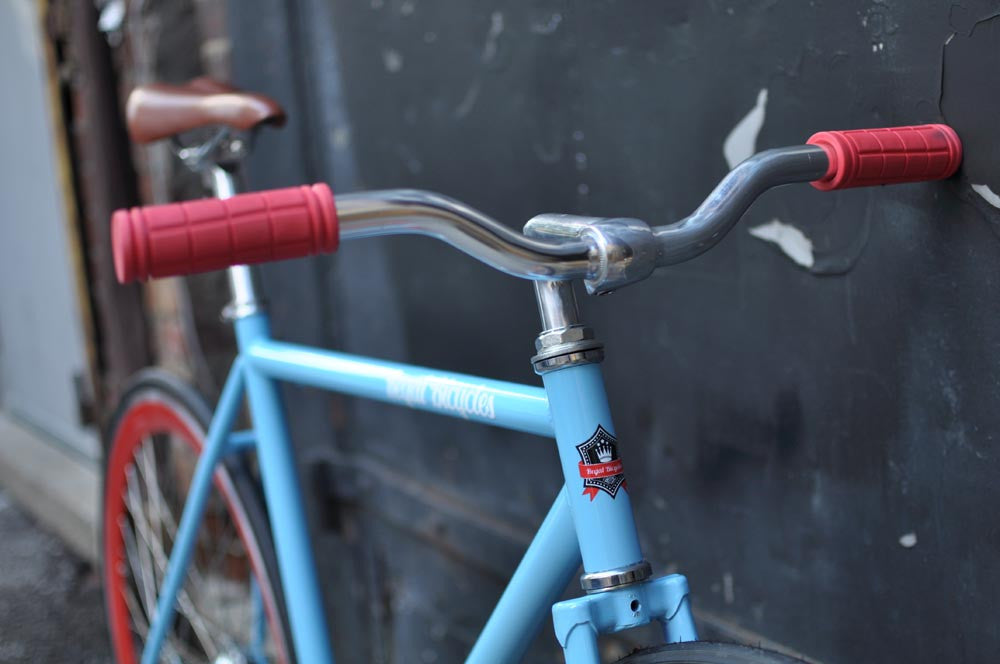 This fixed gear bicycle is called "The Maquis" and features red rims and a sky blue frame.