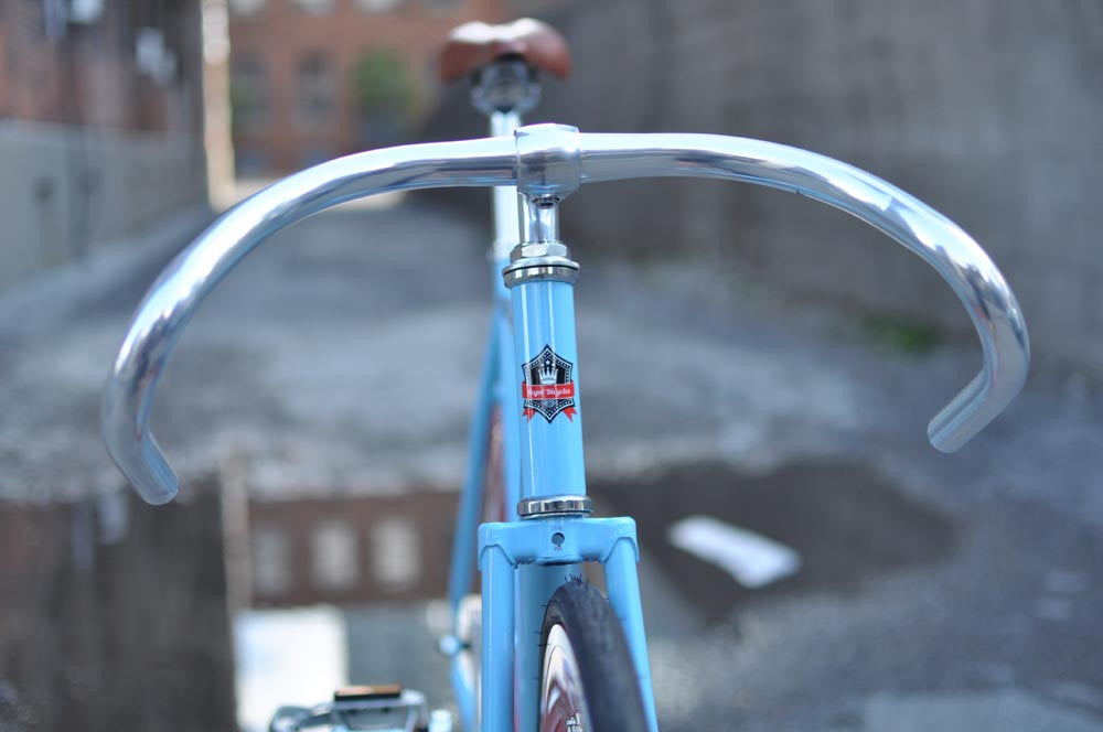 This fixed gear bicycle is called "The Maquis" and features red rims and a sky blue frame.