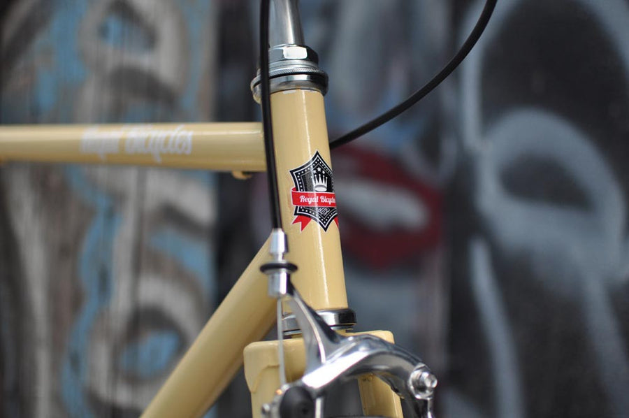 This fixed gear bicycle is called "The Count" and features white rims and a cream frame.