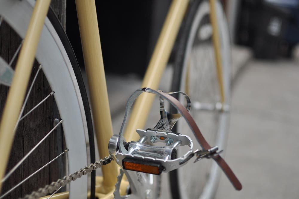 This fixed gear bicycle is called "The Count" and features white rims and a cream frame.