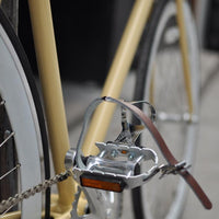 This fixed gear bicycle is called "The Count" and features white rims and a cream frame.