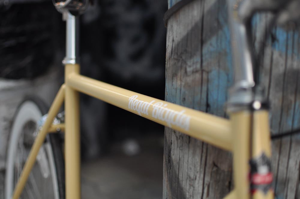 This fixed gear bicycle is called "The Count" and features white rims and a cream frame.