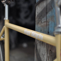 This fixed gear bicycle is called "The Count" and features white rims and a cream frame.