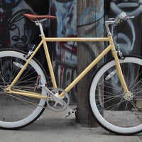 This fixed gear bicycle is called "The Count" and features white rims and a cream frame.