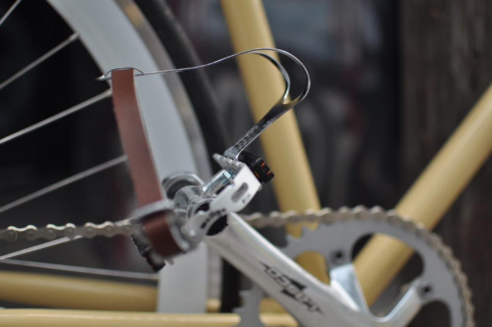 This fixed gear bicycle is called "The Count" and features white rims and a cream frame.