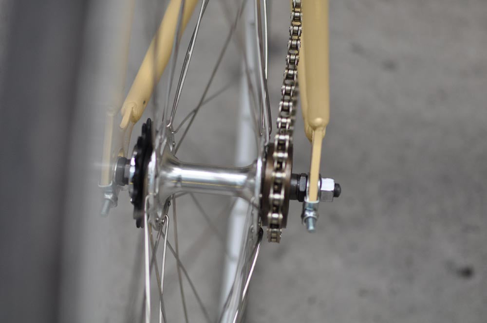 This fixed gear bicycle is called "The Count" and features white rims and a cream frame.