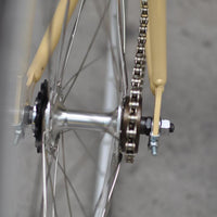 This fixed gear bicycle is called "The Count" and features white rims and a cream frame.