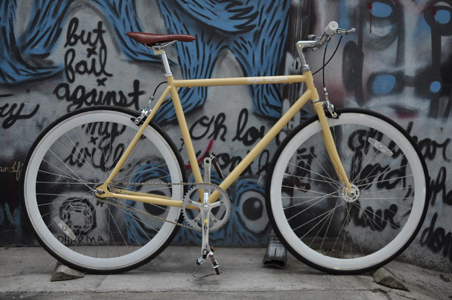 This fixed gear bicycle is called "The Count" and features white rims and a cream frame.