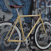 This fixed gear bicycle is called "The Count" and features white rims and a cream frame.