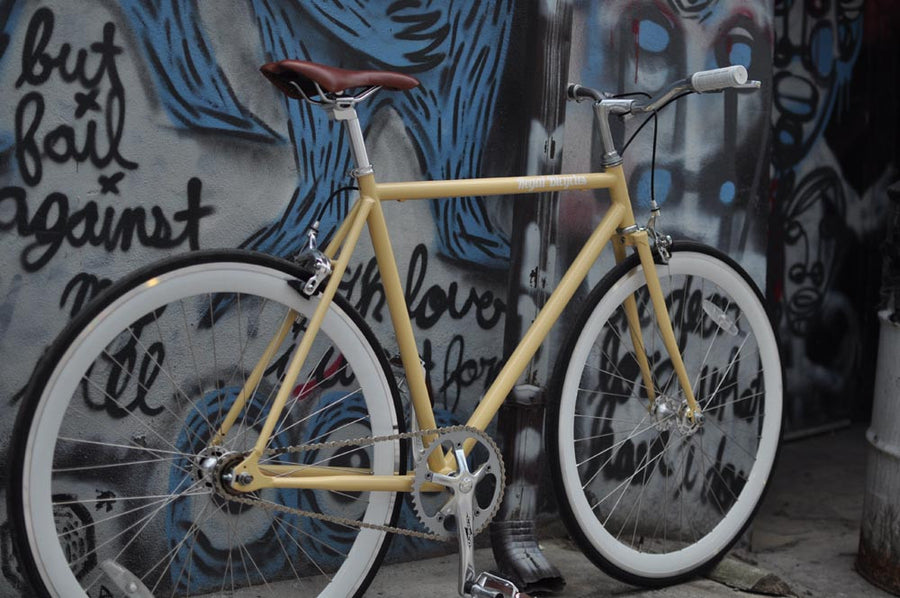 This fixed gear bicycle is called "The Count" and features white rims and a cream frame.