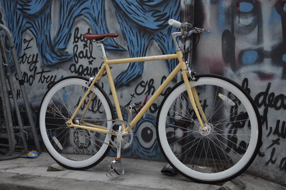 This fixed gear bicycle is called "The Count" and features white rims and a cream frame.