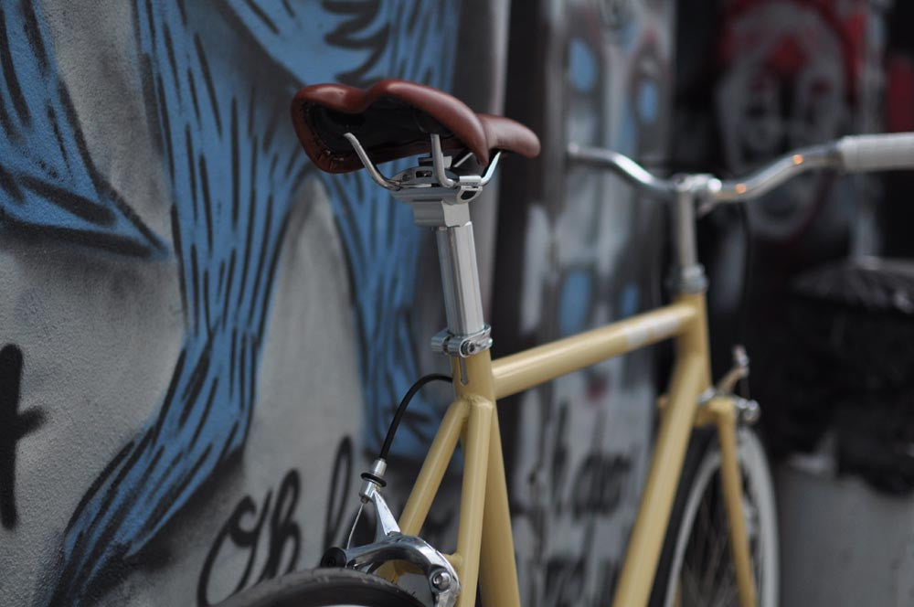 This fixed gear bicycle is called "The Count" and features white rims and a cream frame.