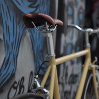 This fixed gear bicycle is called "The Count" and features white rims and a cream frame.