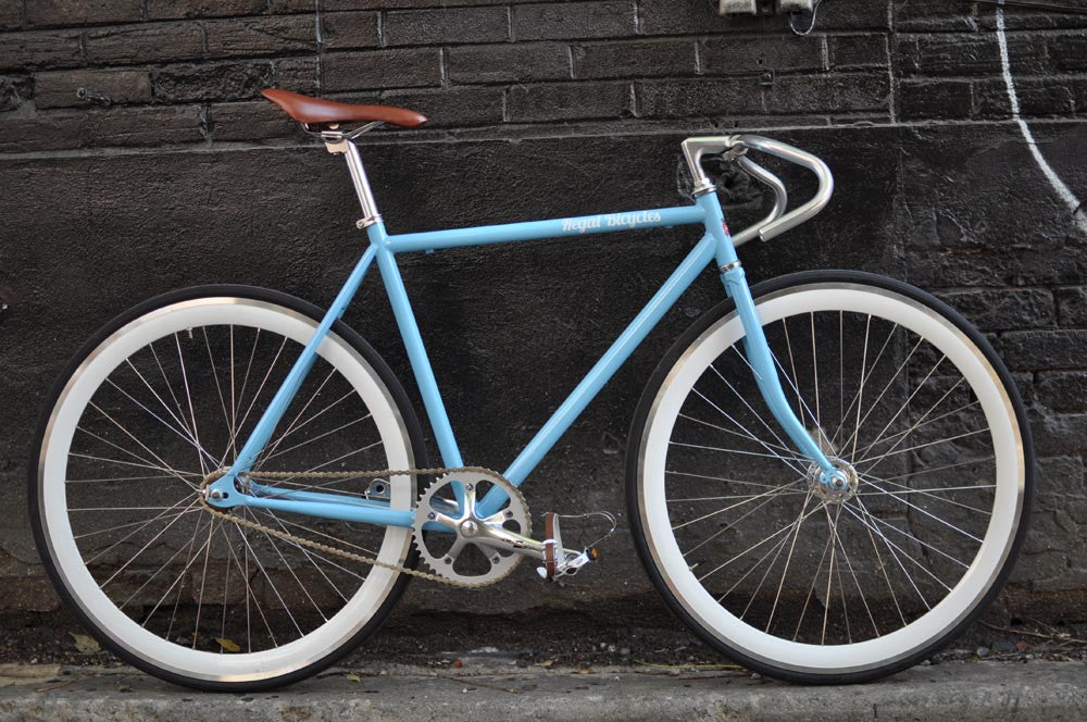 This fixed gear bicycle is called "The Prince" and features white rims and a sky blue frame.