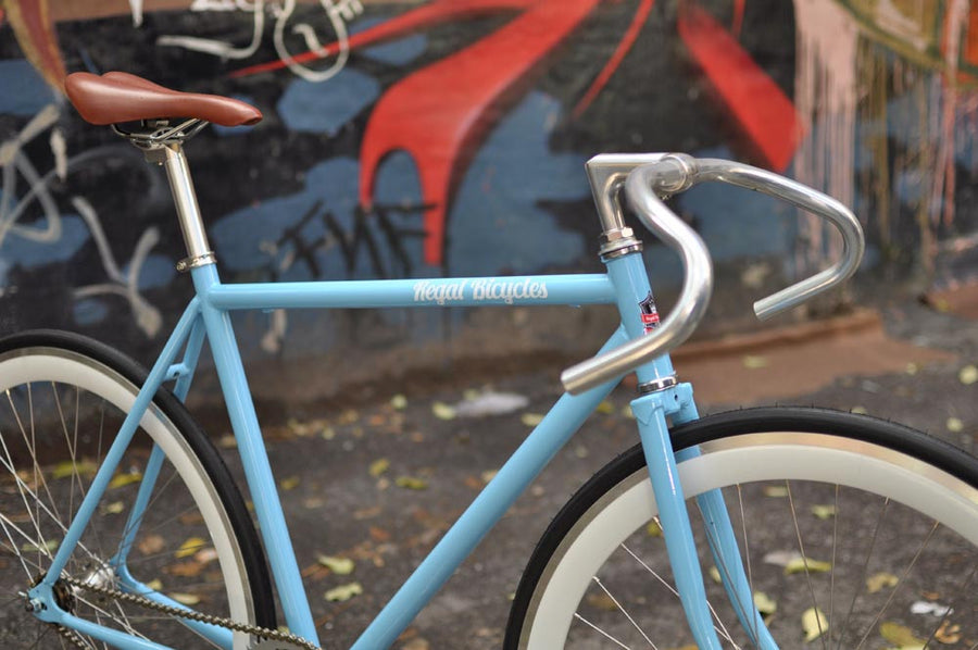 This fixed gear bicycle is called "The Prince" and features white rims and a sky blue frame.