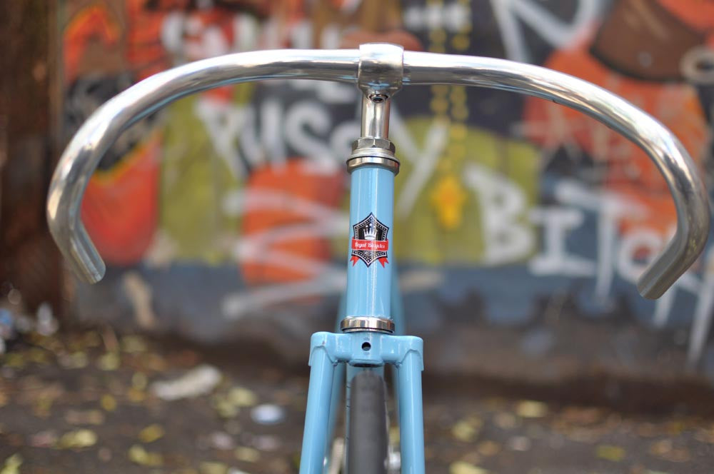 This fixed gear bicycle is called "The Prince" and features white rims and a sky blue frame.