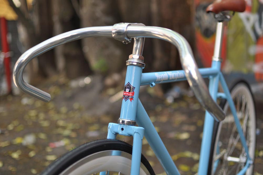 This fixed gear bicycle is called "The Prince" and features white rims and a sky blue frame.