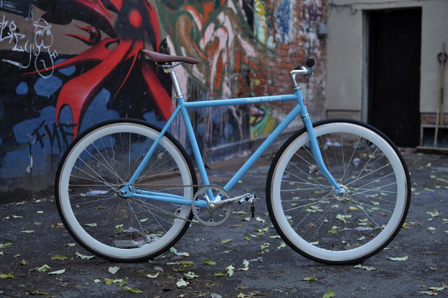 This fixed gear bicycle is called "The Prince" and features white rims and a sky blue frame.