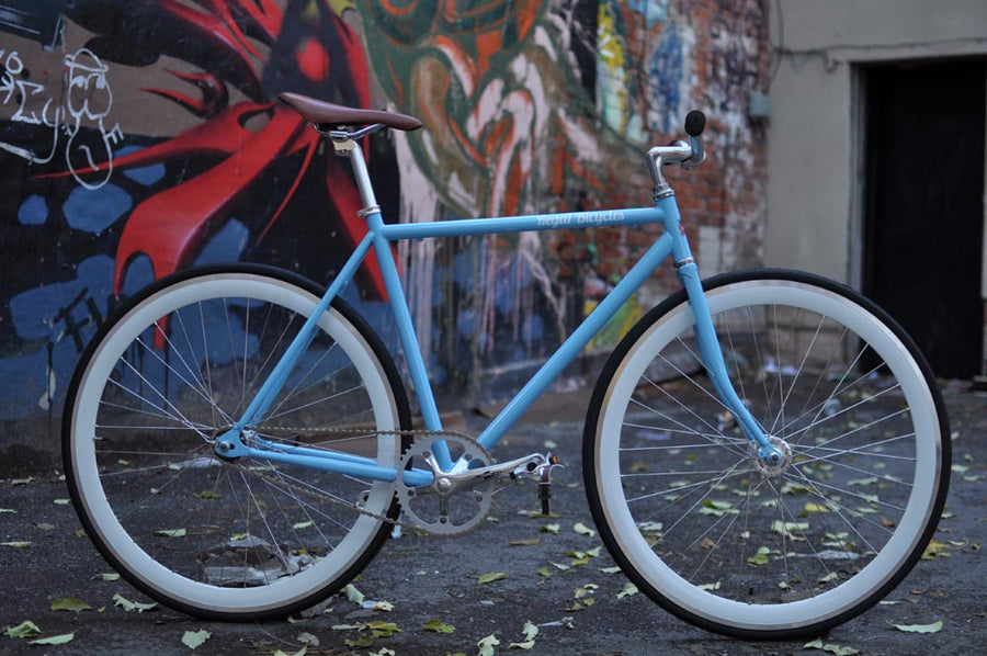 This fixed gear bicycle is called "The Prince" and features white rims and a sky blue frame.