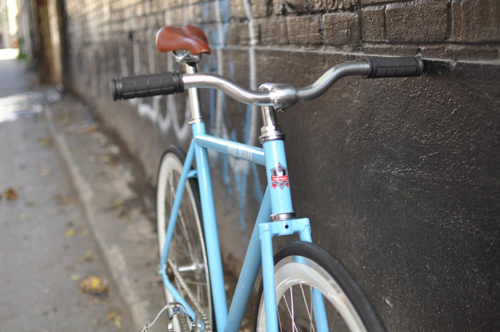 This fixed gear bicycle is called "The Prince" and features white rims and a sky blue frame.