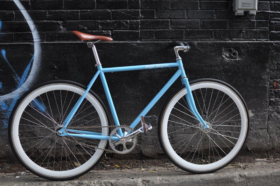 This fixed gear bicycle is called "The Prince" and features white rims and a sky blue frame.