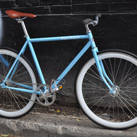 This fixed gear bicycle is called "The Prince" and features white rims and a sky blue frame.