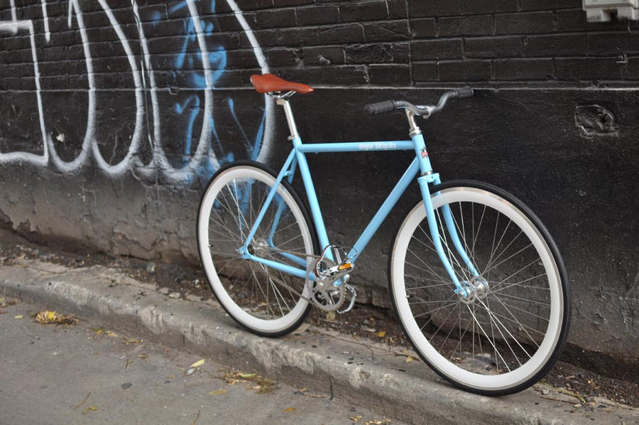 This fixed gear bicycle is called "The Prince" and features white rims and a sky blue frame.