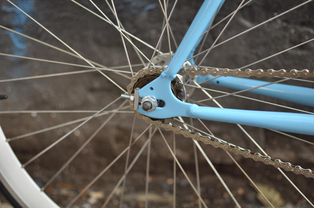 This fixed gear bicycle is called "The Prince" and features white rims and a sky blue frame.