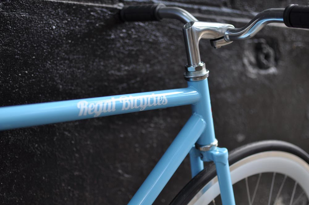 This fixed gear bicycle is called "The Prince" and features white rims and a sky blue frame.