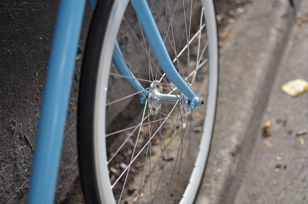 This fixed gear bicycle is called "The Prince" and features white rims and a sky blue frame.